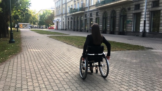Kobieta jedzie na wózku po chodniku