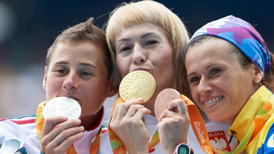 Trzy uradowane kobiety prezentują swoje medale