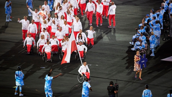 Reprezentanci Polski wychodzą na stadion podczas ceremonii otwarcia igrzysk. Biało-czerwoną flagę niesie zawodnik poruszający się na wózku